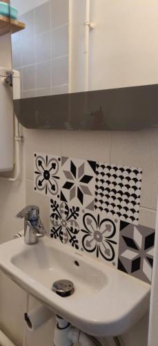 a bathroom with a sink and flowers on the wall at Cosy Appartement Paris Ouest in Suresnes