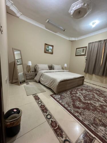 a bedroom with a large bed and a rug at دار هند شقق مفروشة بحي سكني in Al Madinah
