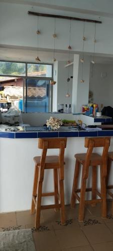 kuchnia z dwoma drewnianymi stołkami przy ladzie w obiekcie casa pernia w mieście San Silvestre
