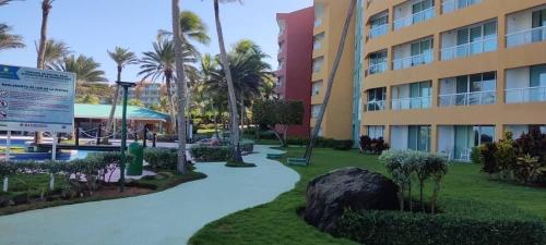 a walkway in front of a building with palm trees at Cimarron Suites Playa Parguito in El Cardón