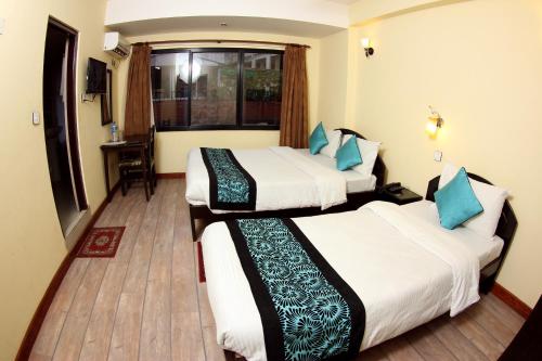 a hotel room with two beds and a window at Bag Packer's Lodge in Kathmandu