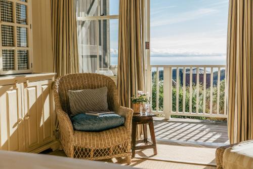 a living room with a chair and a balcony at Rosewood Cape Kidnappers in Te Awanga
