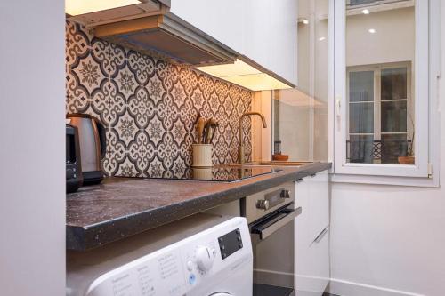 - une cuisine avec un comptoir et une cuisinière dans l'établissement Élégant appartement 1 chambre pour 4 personnes au cœur de Paris, à Bastille, à Paris