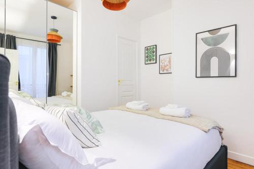 une chambre avec un lit blanc et un miroir dans l'établissement Élégant appartement 1 chambre pour 4 personnes au cœur de Paris, à Bastille, à Paris
