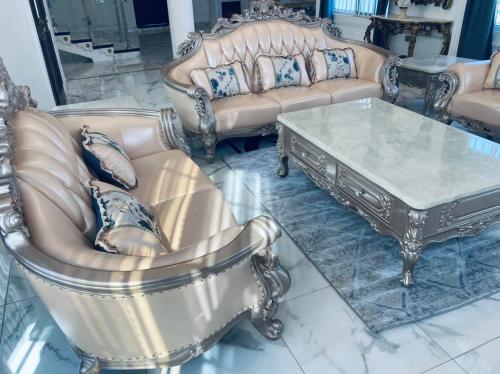 a living room with couches and a coffee table at The Peacock Mansion in Kumasi