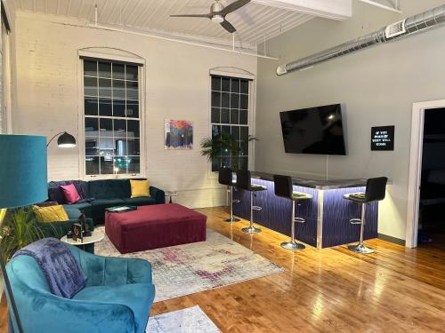 un soggiorno con divano e TV a schermo piatto di Penthouse: Casa Colore a Utica