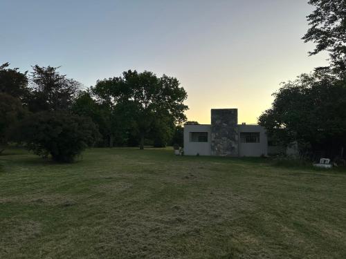 a building in a field next to a grass field at Las Marias in Tandil