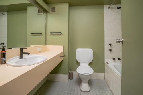 a bathroom with a white toilet and a sink at All Seasons Motel Armidale in Armidale