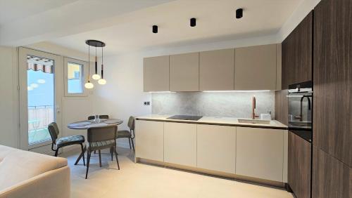 une cuisine et une salle à manger avec une table et des chaises dans l'établissement CANNES BANANE 3 pièces rénové tout équipé au coeur de Cannes - GARAGE PRIVE, à Cannes