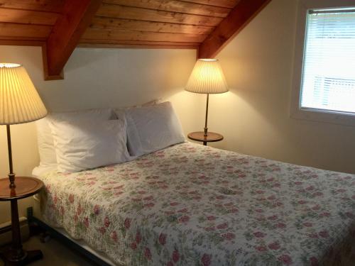 a bedroom with a bed with two lamps at Alexander's Lodge in Ashford
