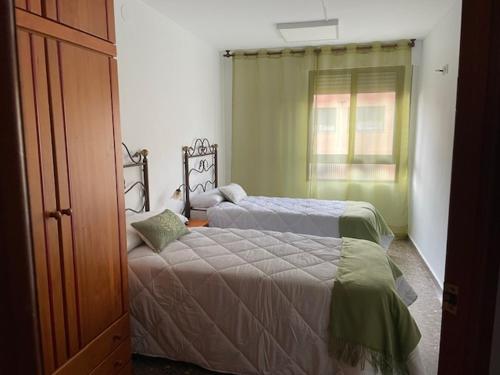 1 dormitorio con 2 camas y ventana en Apartamento Diagonal en Nules