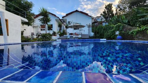 a swimming pool with blue tiles in a house at LA VILLA by luxury Attilan in San Pedro La Laguna