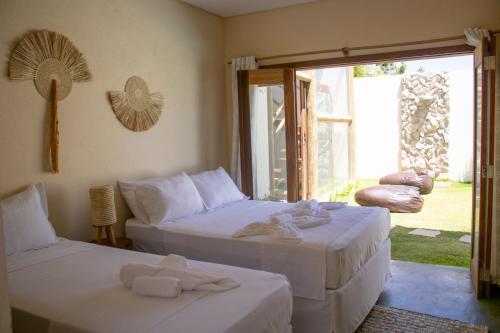 two beds in a room with towels on them at Pousada Veleiro Kite Preá in Prea