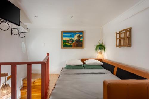 a living room with a bed and a couch at Casa Aurora - bairro típico a minutos do Terreiro in Lisbon