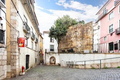 an alley in an old city with buildings at Casa Aurora - bairro típico a minutos do Terreiro in Lisbon