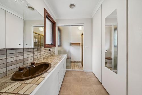 a bathroom with a sink and a mirror at Rosella Retreat in Blackheath