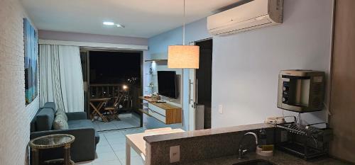 a living room with a television and a living room with a couch at VG Sun Cumbuco Sea Breeze Vista Mar in Cumbuco