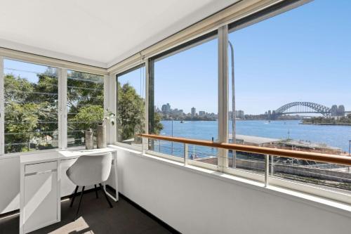 an office with large windows and a view of the sydney harbour at Balmain Wharf l 2 Bedroom Apartment in Sydney