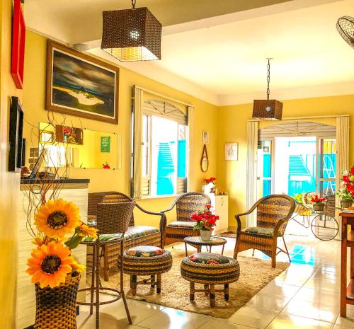 ein Wohnzimmer mit Stühlen und einem Tisch mit Sonnenblumen in der Unterkunft Pousada Casa do Ivo Santarém in Santarém