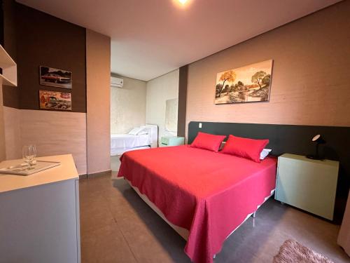 1 dormitorio con 1 cama con manta roja en Pousada Recanto da Estação en São João da Boa Vista