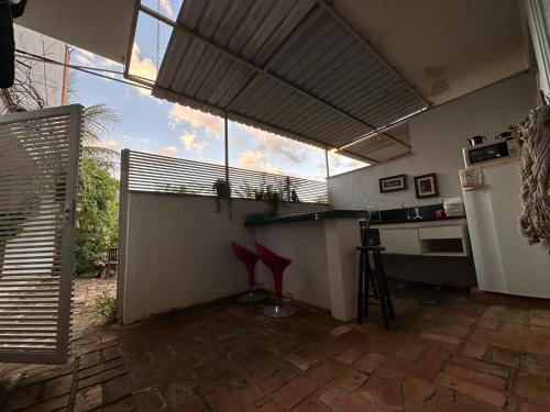 a kitchen with red stools in a room with a window at Pousada Recanto da Estação in São João da Boa Vista