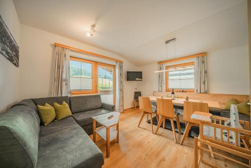 ein Wohnzimmer mit einem Sofa und einem Esszimmer in der Unterkunft Appartement Gamper in Brixen im Thale