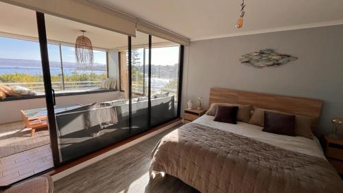 a bedroom with a bed and a large window at Depto de lujo en Punta Fraile, frente mar, 140 m2, amplias areas verdes, piscina, hamaca, tranquilidad in Algarrobo