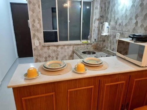 eine Küche mit Tellern und Schüsseln auf der Theke in der Unterkunft Apartamento aconchegante no centro de São Lourenço 700m do Parque das Águas in São Lourenço