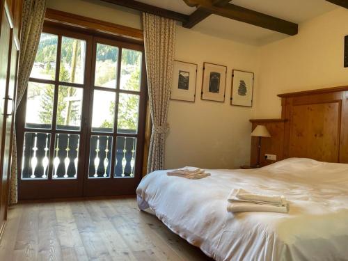 - une chambre avec un lit et une grande fenêtre dans l'établissement Wasserfallweg 17, à Bad Kleinkirchheim