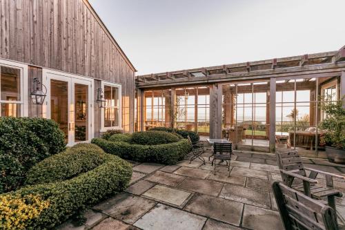 a patio with chairs and bushes in a building at Rosewood Cape Kidnappers in Te Awanga