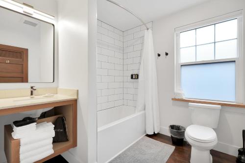 a white bathroom with a toilet and a sink at Summit Lofts Boutique Hotel in Mount Shasta