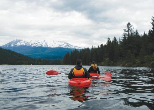 a man and a woman in a kayak on a lake at Summit Lofts Boutique Hotel in Mount Shasta