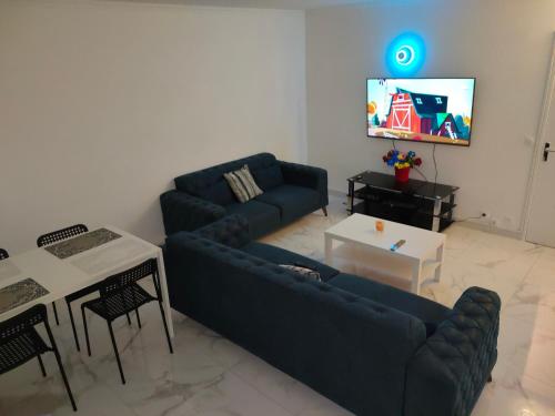 sala de estar con sofá azul y TV en Mon superbe appartement en Argenteuil