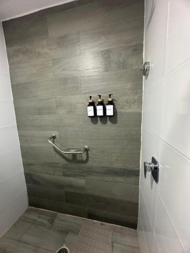 - une salle de bains avec 3 bouteilles de vin sur le mur dans l'établissement FIESTA MIRAMAR, à Ciudad Madero