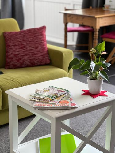 a white coffee table with a potted plant on it at Tutukaka Sunrise in Tutukaka