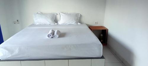 dos zapatos sentados en la parte superior de una cama en Giri Homestay, en Amed