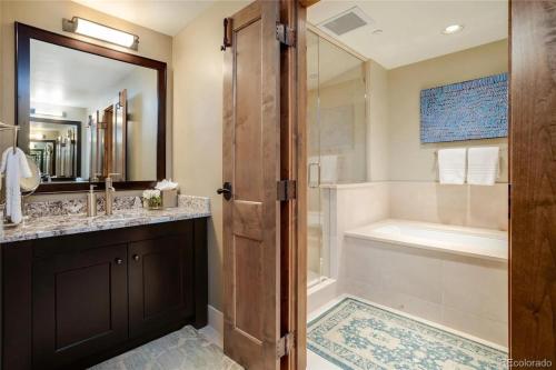 a bathroom with a tub and a sink and a shower at Edgemont 2301 Luxury Condo with Backdoor Ski-In Ski-Out Access! in Steamboat Springs