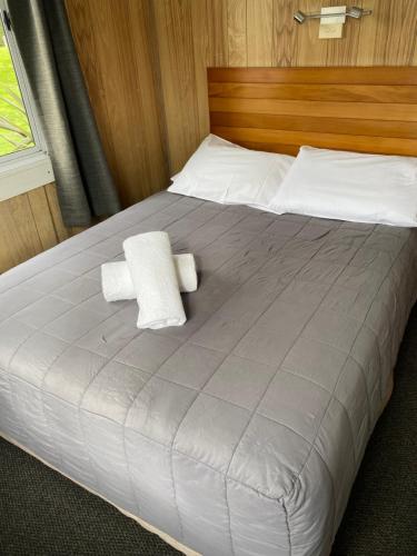 a large bed with two white towels on it at Rotorua Thermal Holiday Park in Rotorua