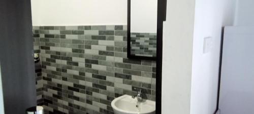 baño con lavabo y pared de azulejos en Giri Homestay en Amed