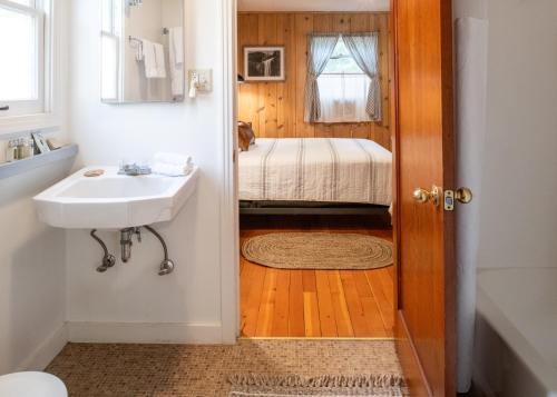 a small bathroom with a sink and a bed at Inn at Sugar Pine Ranch in Groveland