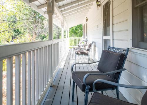 a porch with two rocking chairs on a house at Inn at Sugar Pine Ranch in Groveland
