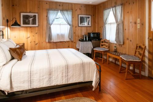 a bedroom with a bed and a table and chairs at Inn at Sugar Pine Ranch in Groveland