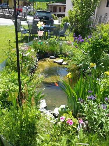 a pond in the middle of a garden with flowers at Ferienwohnungen Trinker - Lungau Karte inklusive in Ramingstein