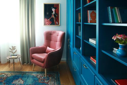 soggiorno con sedia rosa e armadietto blu di Premium Central Apartment a Braşov