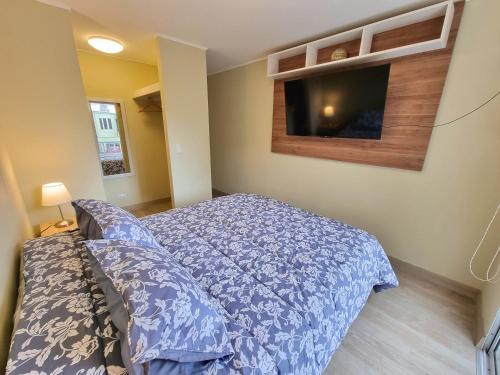 a bedroom with a bed and a tv on the wall at Hermoso y céntrico 1BR en Barranco con cochera wifi y netflix in Lima