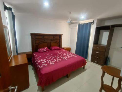 - une chambre avec un grand lit et un couvre-lit violet dans l'établissement Casa de 3 recamaras frente al parque, à Mérida