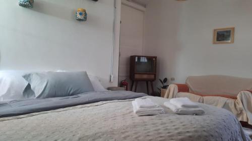 a bedroom with a bed with two towels on it at Bataclana Hospedaje y Residencia en Caminito in Buenos Aires
