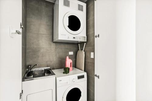 a kitchen with a washing machine and a sink at Modern 2BD in Trendy Inner West in Sydney