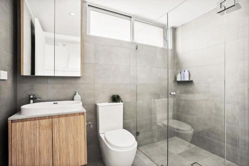 La salle de bains est pourvue de toilettes, d'un lavabo et d'une douche. dans l'établissement Modern 2BD in Trendy Inner West, à Sydney