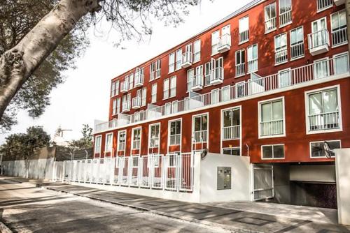 a large red brick building with a white fence at Hermoso y céntrico 1BR en Barranco con cochera wifi y netflix in Lima